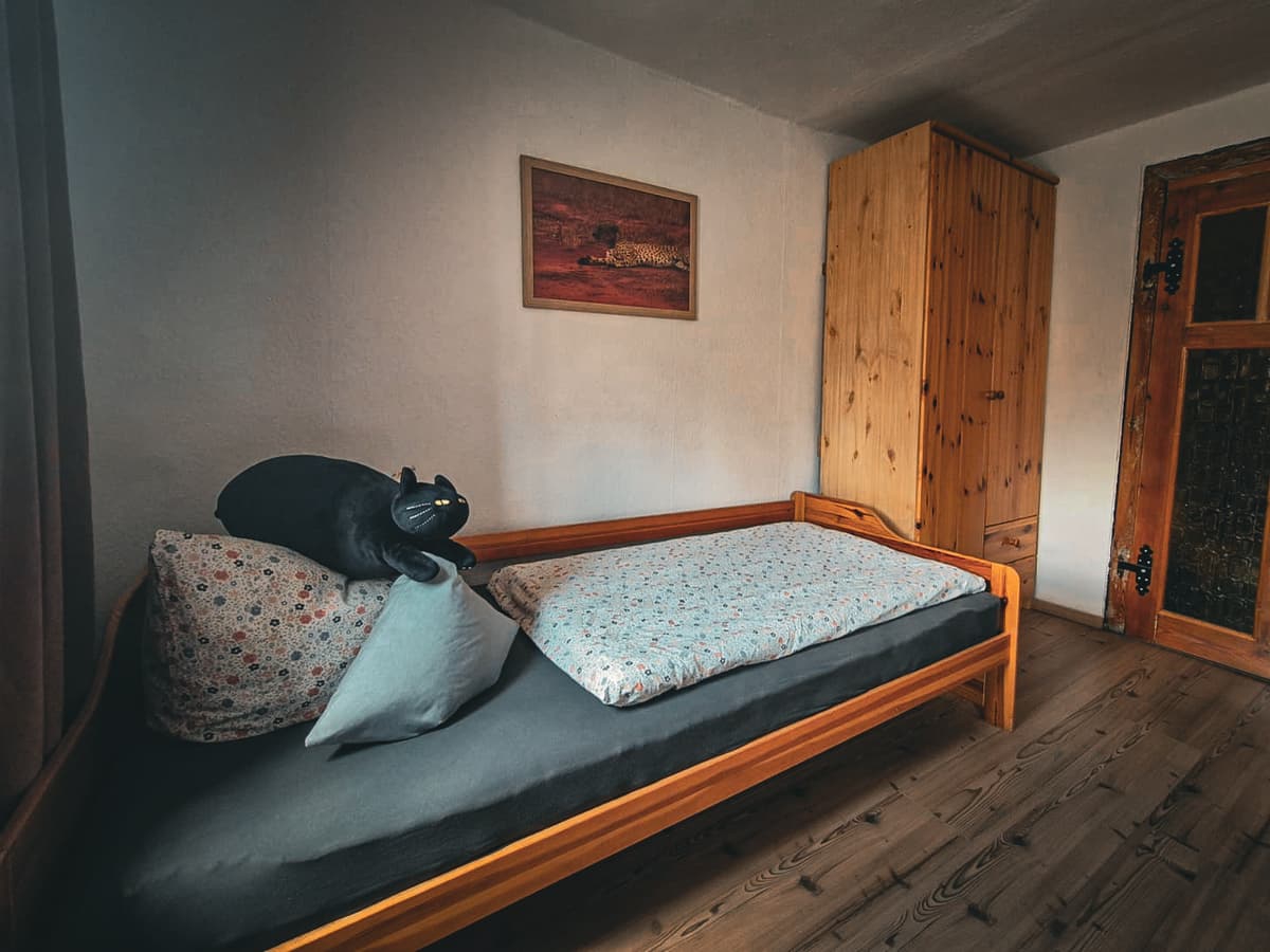 Einzelbett und Holzschrank im Familienzimmer der großen Ferienwohnung